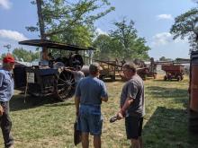 Crowd admiring the steam engines threshing